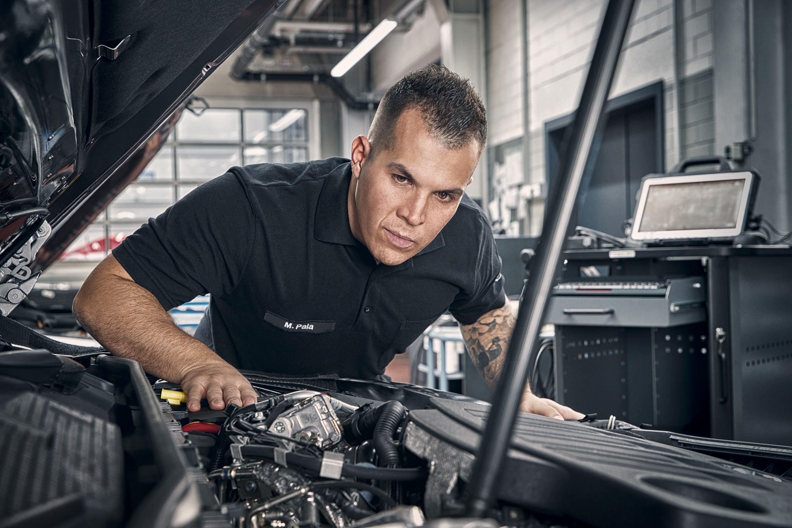 Person beugt sich über Motor