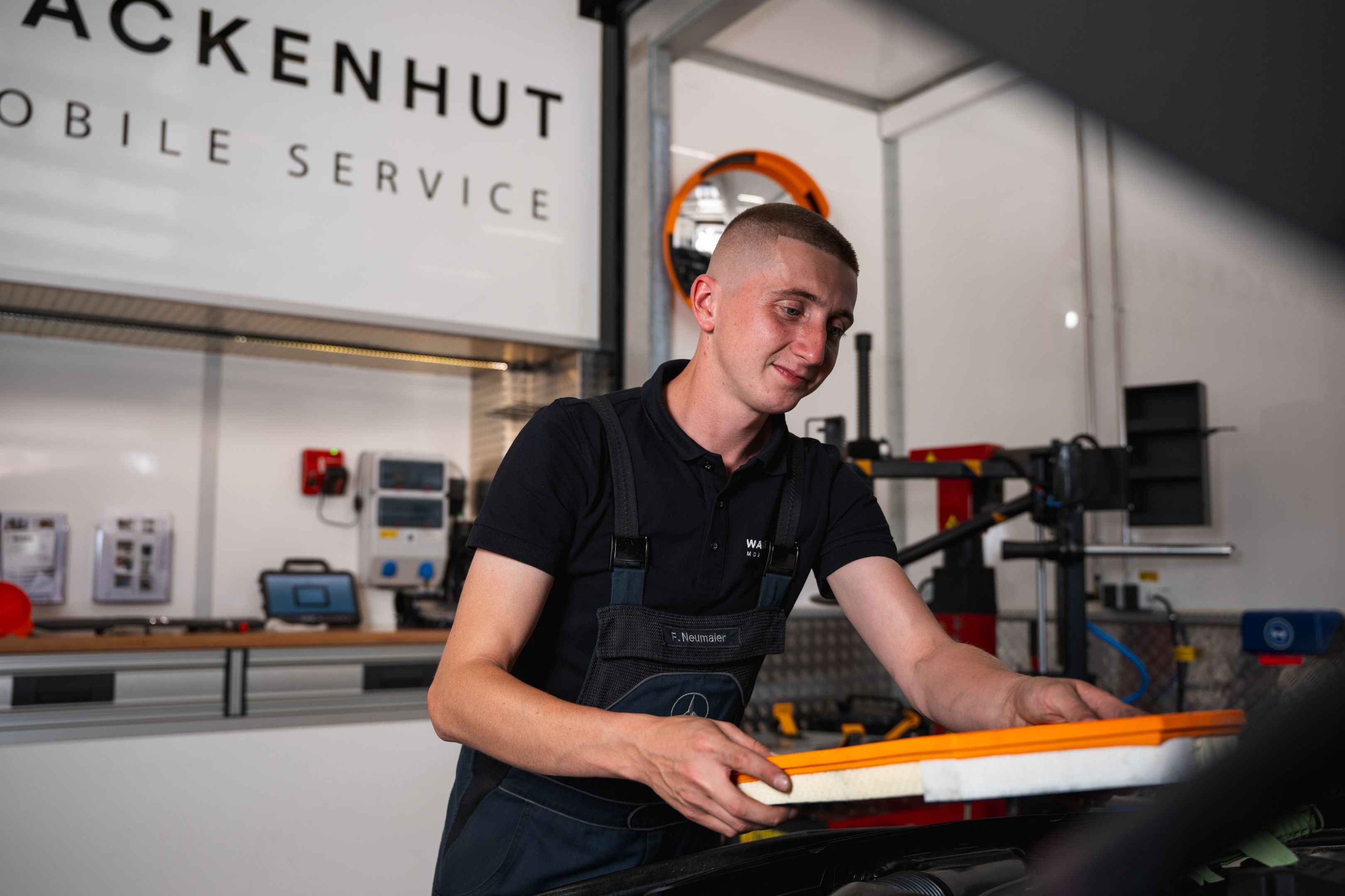 Mechaniker in der mobilen Werkstatt arbeitet an einem Fahrzeug