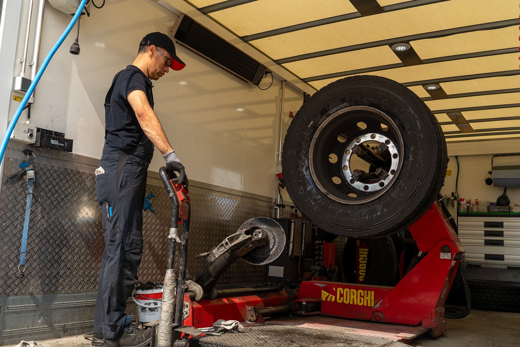 Mechaniker zieht einen neuen LKW Reifen auf eine Felge