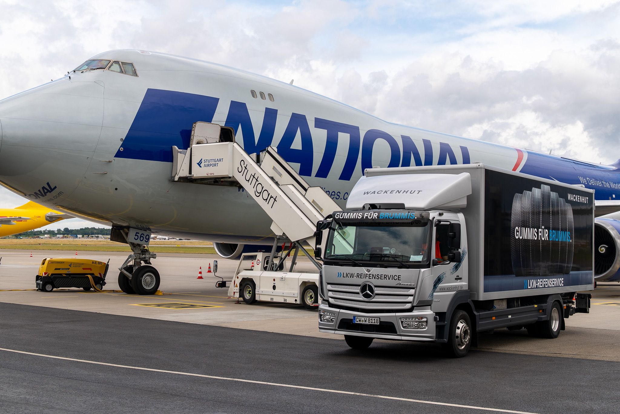 Service-LKW vor einem geparkten Transportflugzeug