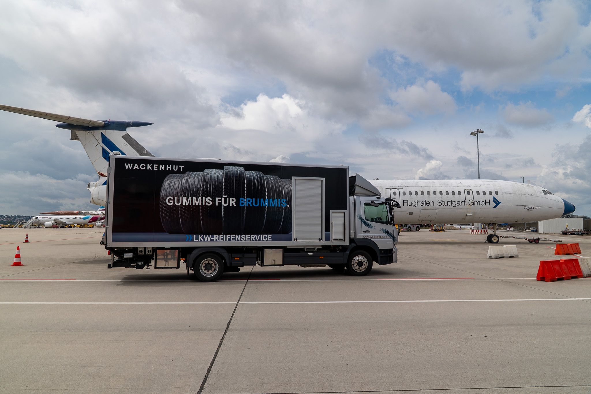 Service-LKW auf Rollfeld vor einem Flugzeug