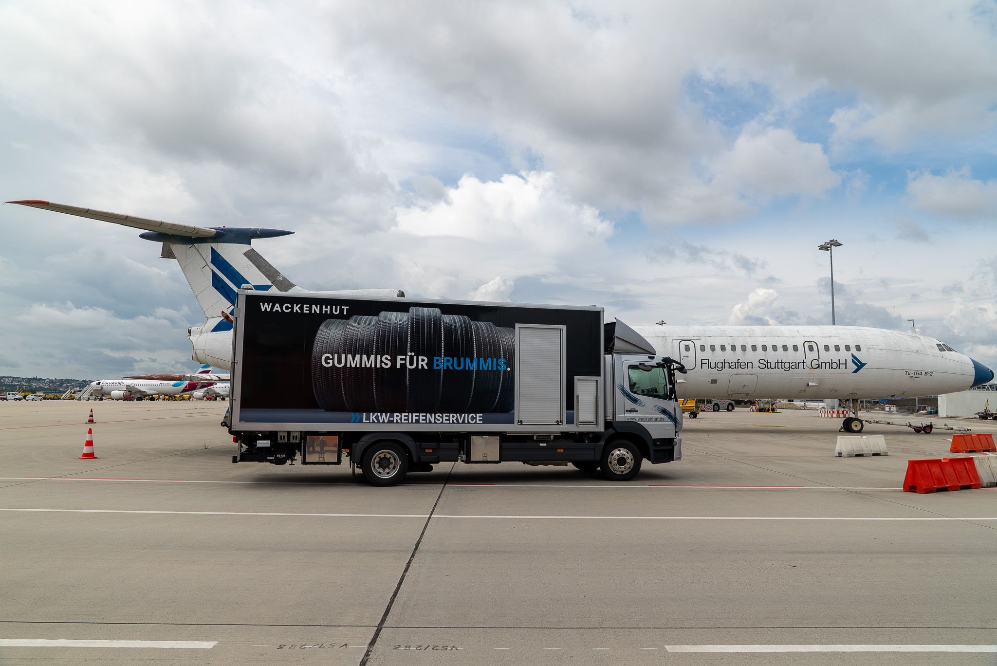 Service-LKW auf Rollfeld vor einem Flugzeug