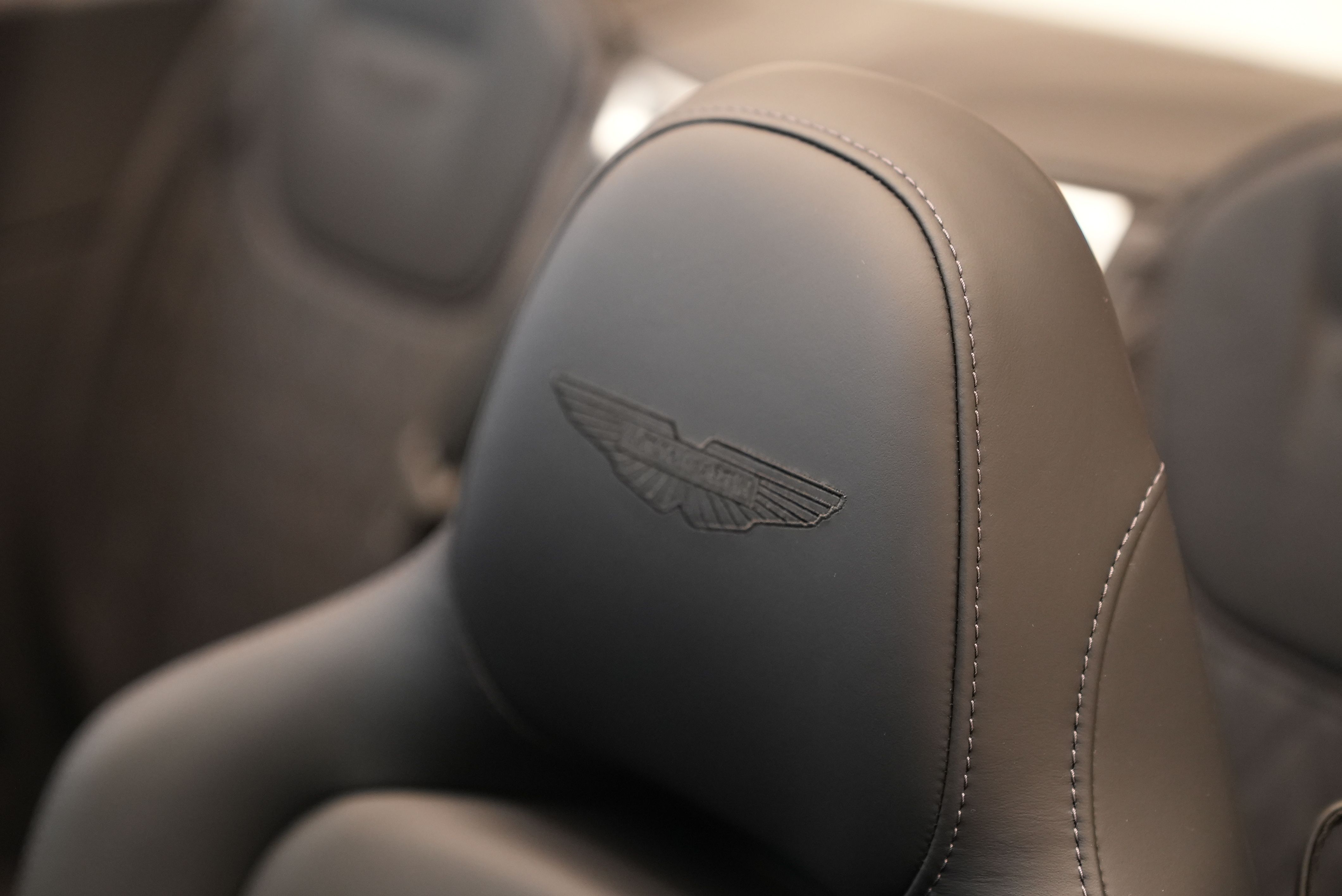 Eine Kopfstütze mit Aston Martin Logo.