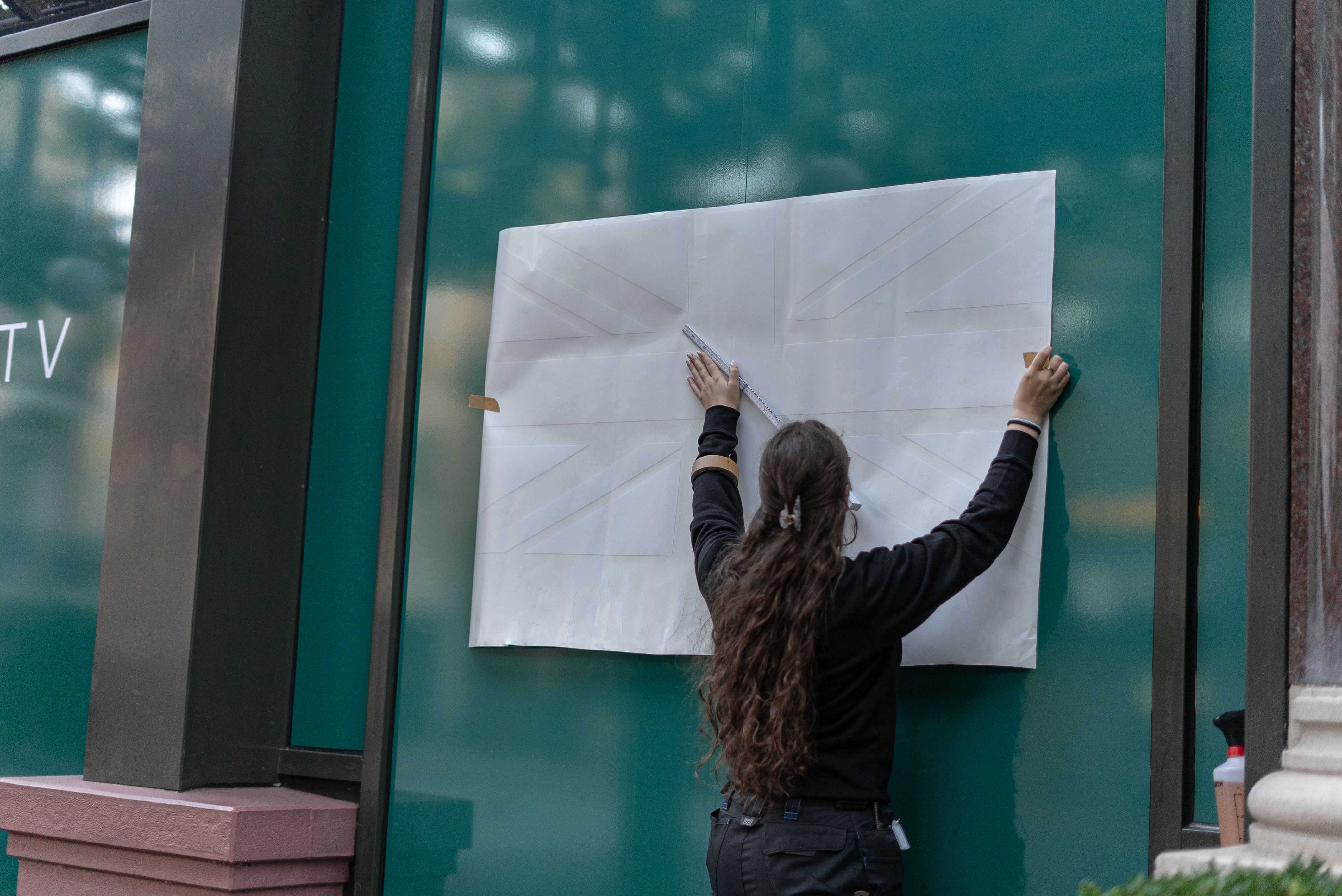 Person bringt Folie auf Fenster an