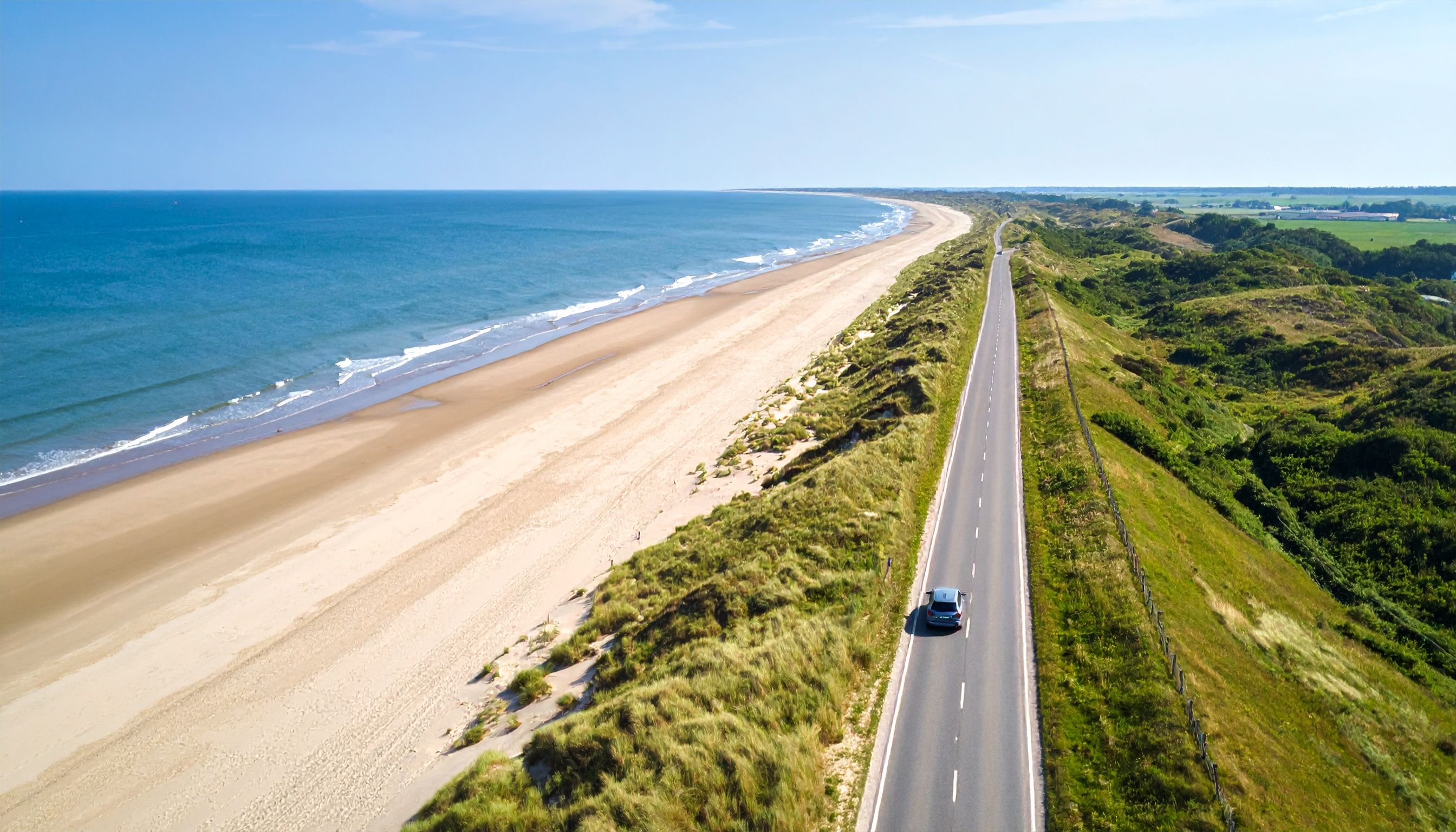 Strandlandschaft von oben mit Fahrzeug auf Straße