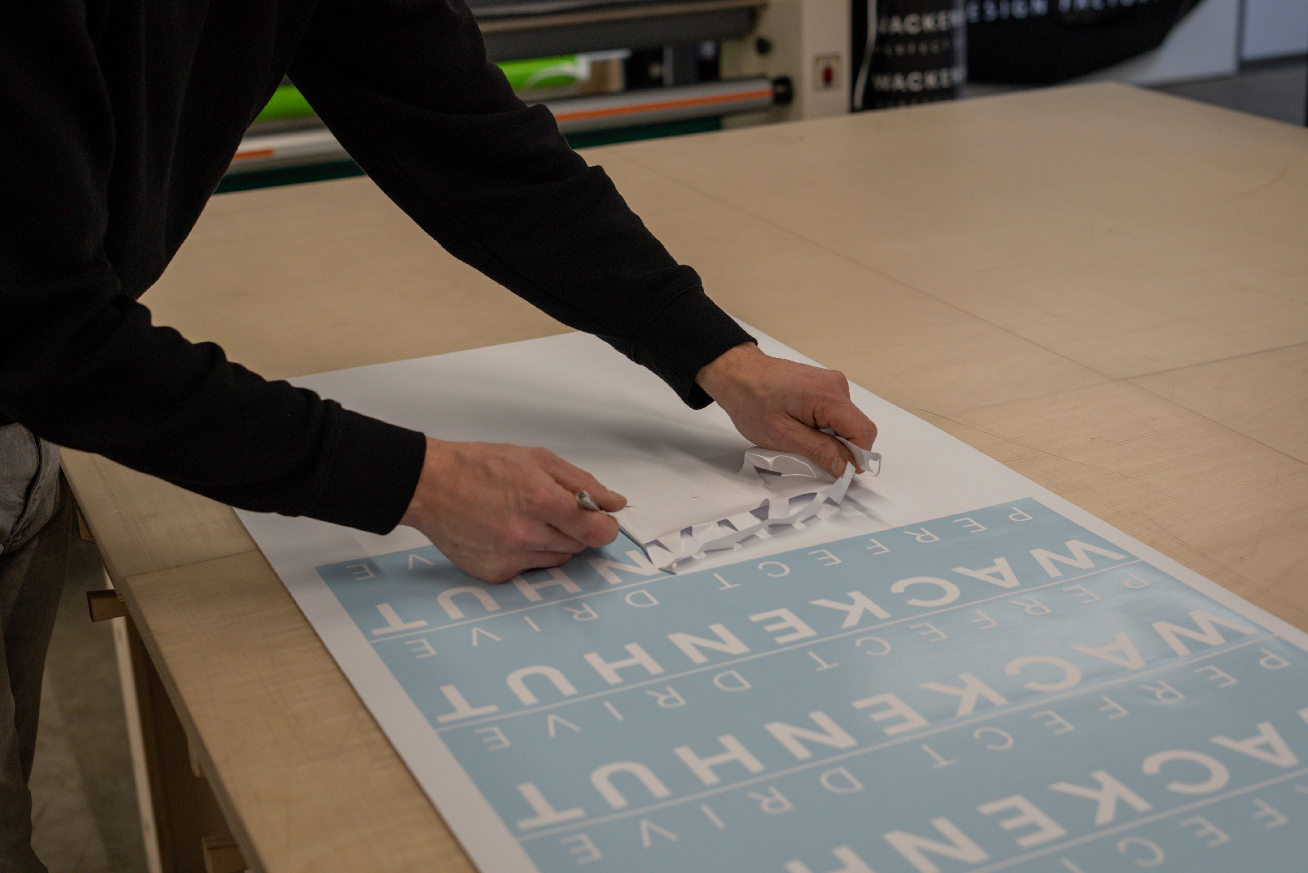 Hände, die eine Folienschrift abziehen