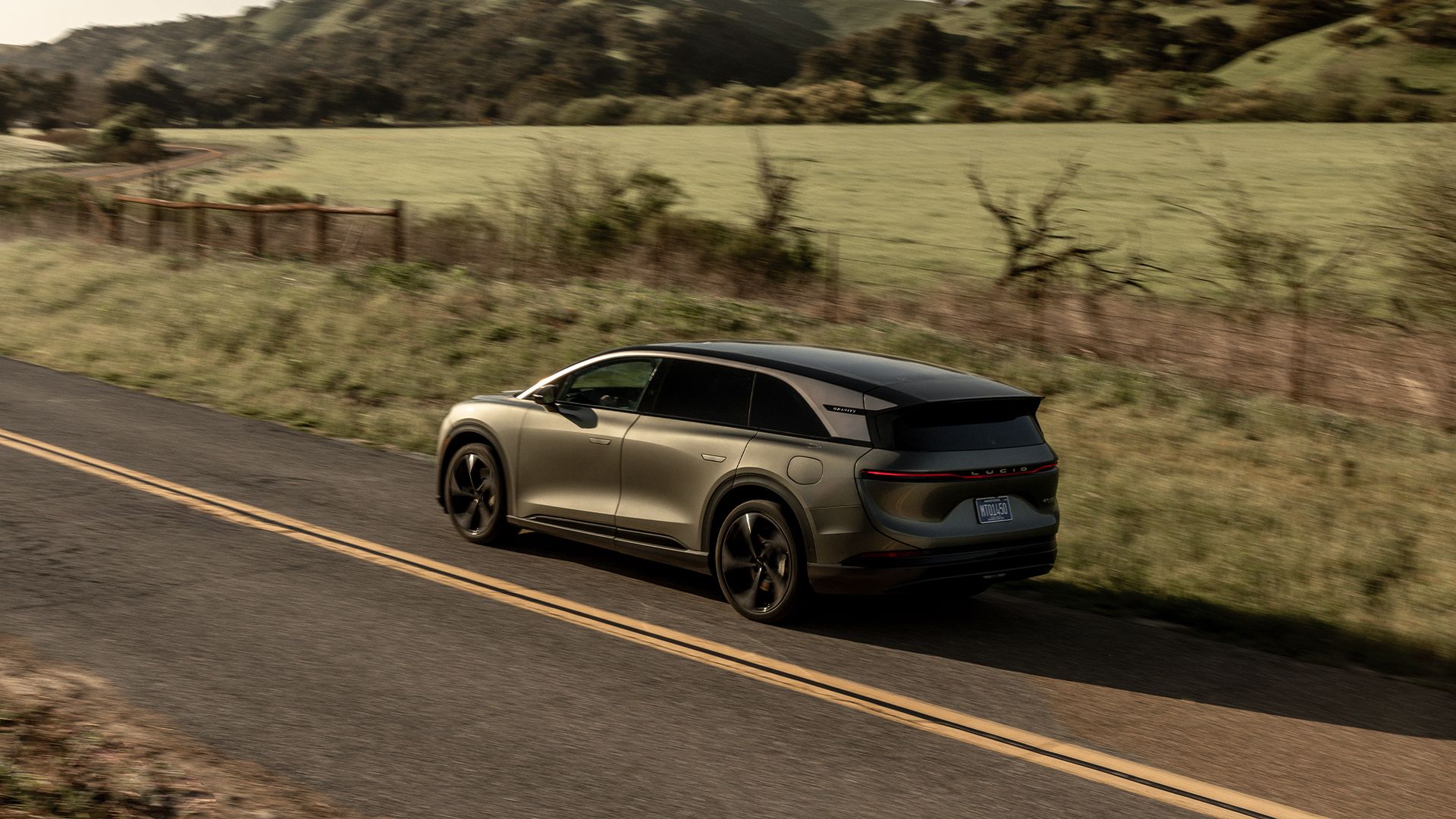 Fahrzeug fährt an einem grünen Feld vorbei