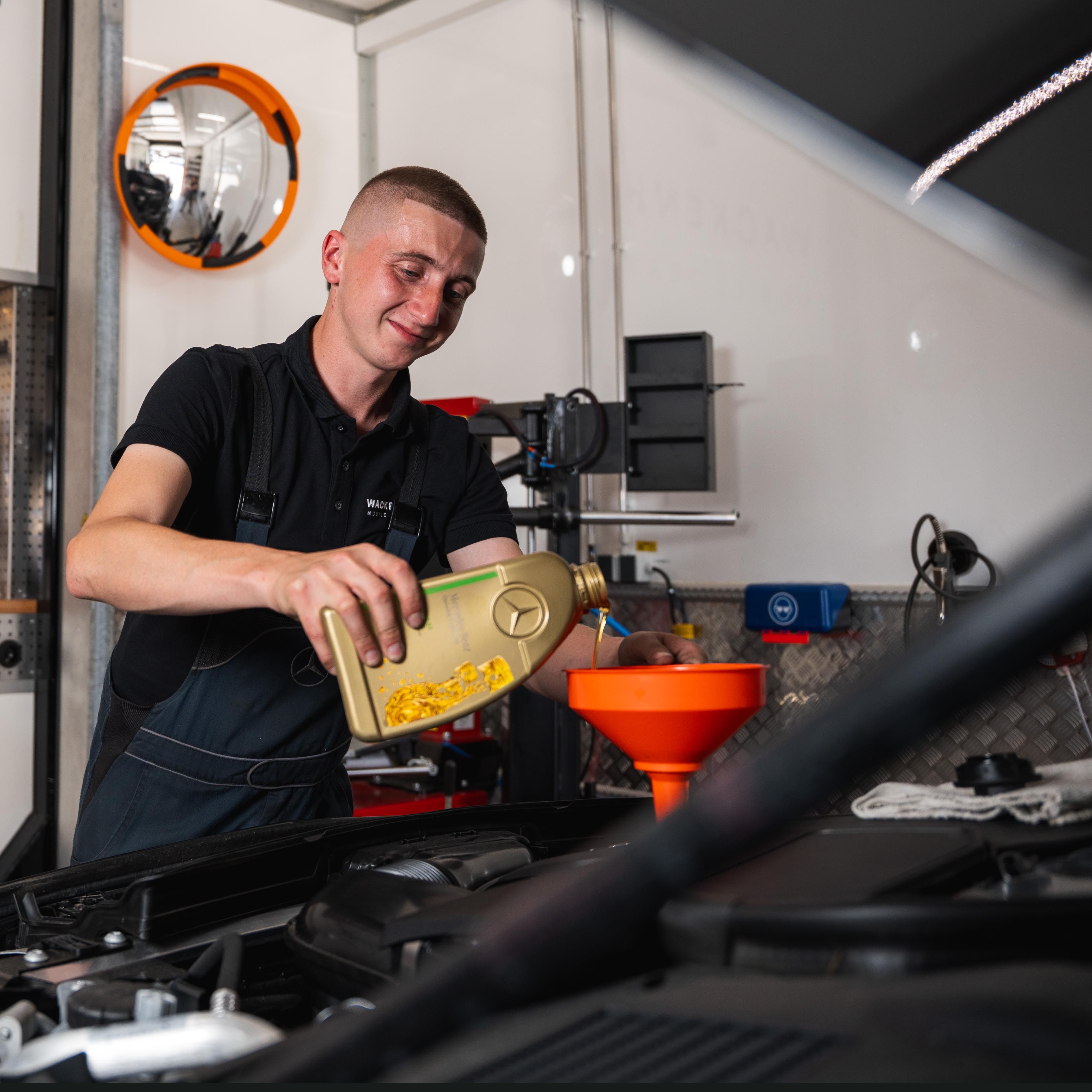 Mann gießt Motoröl ein