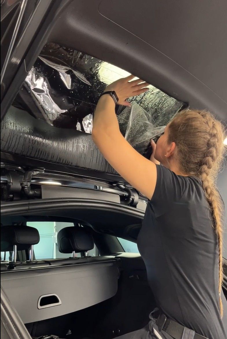 Frau tönt Heckscheibe eines Autos