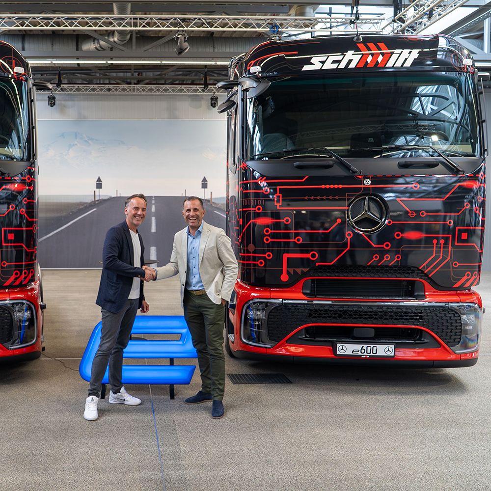 Zwei Personen vor LKW geben sich die Hand