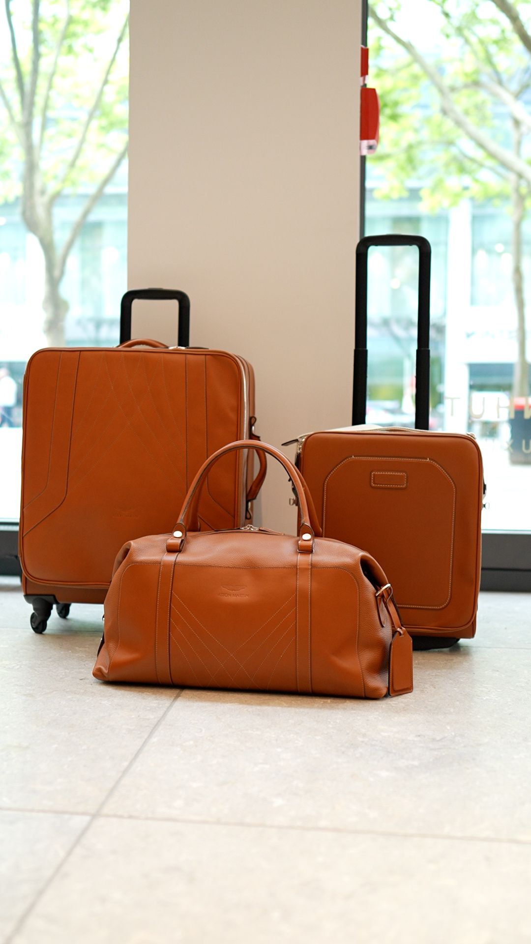 Ein dreiteiliges Travel-Set von Aston Martin in hellbraun.