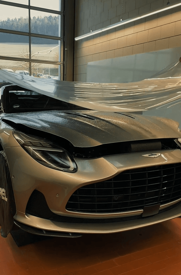 Ein Aston Martin DB12 Volante, auf dem gerade eine Lackschutzfolie angebracht wird