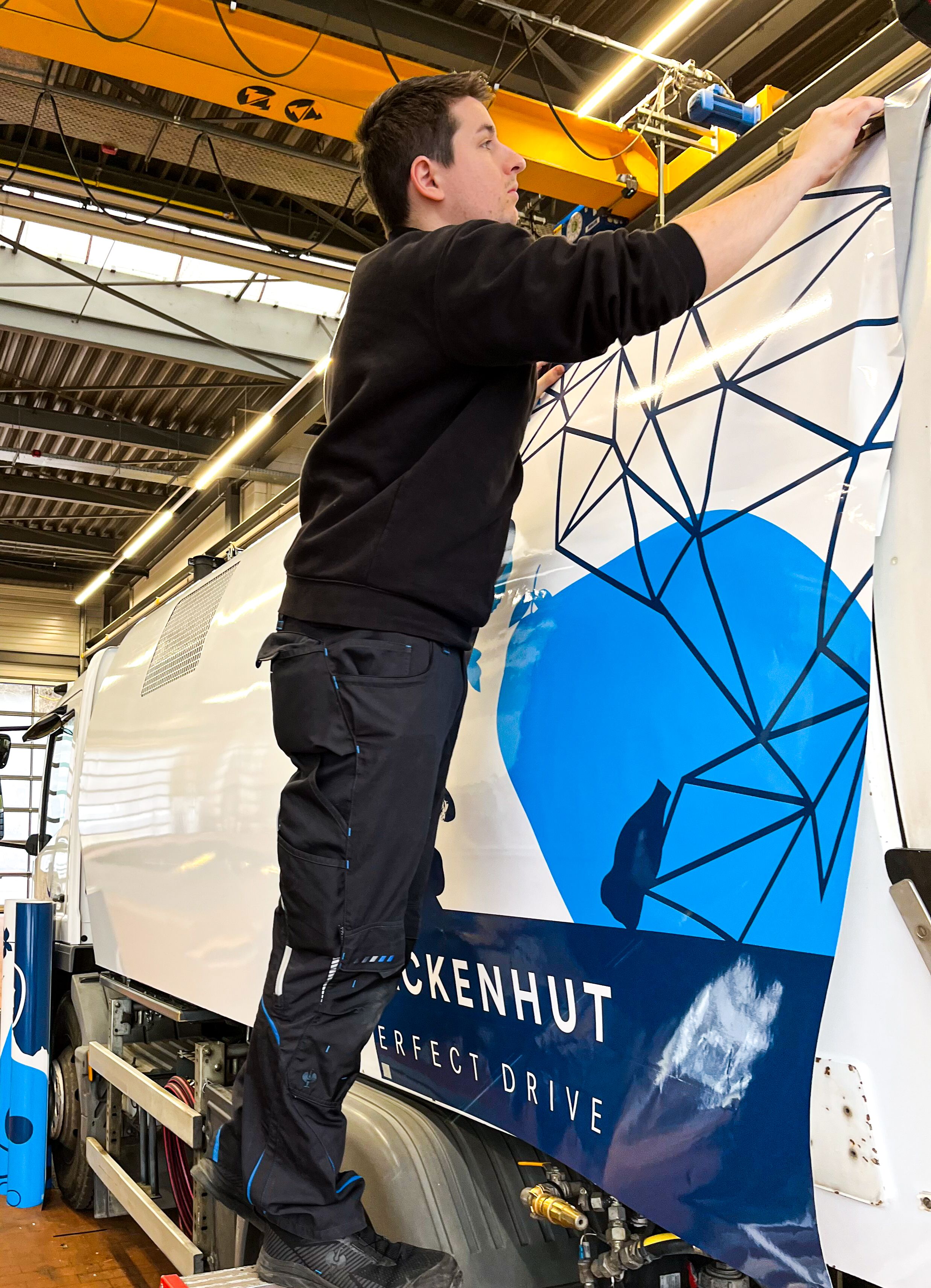 Mann beschriftet Seite der Kehrmaschine